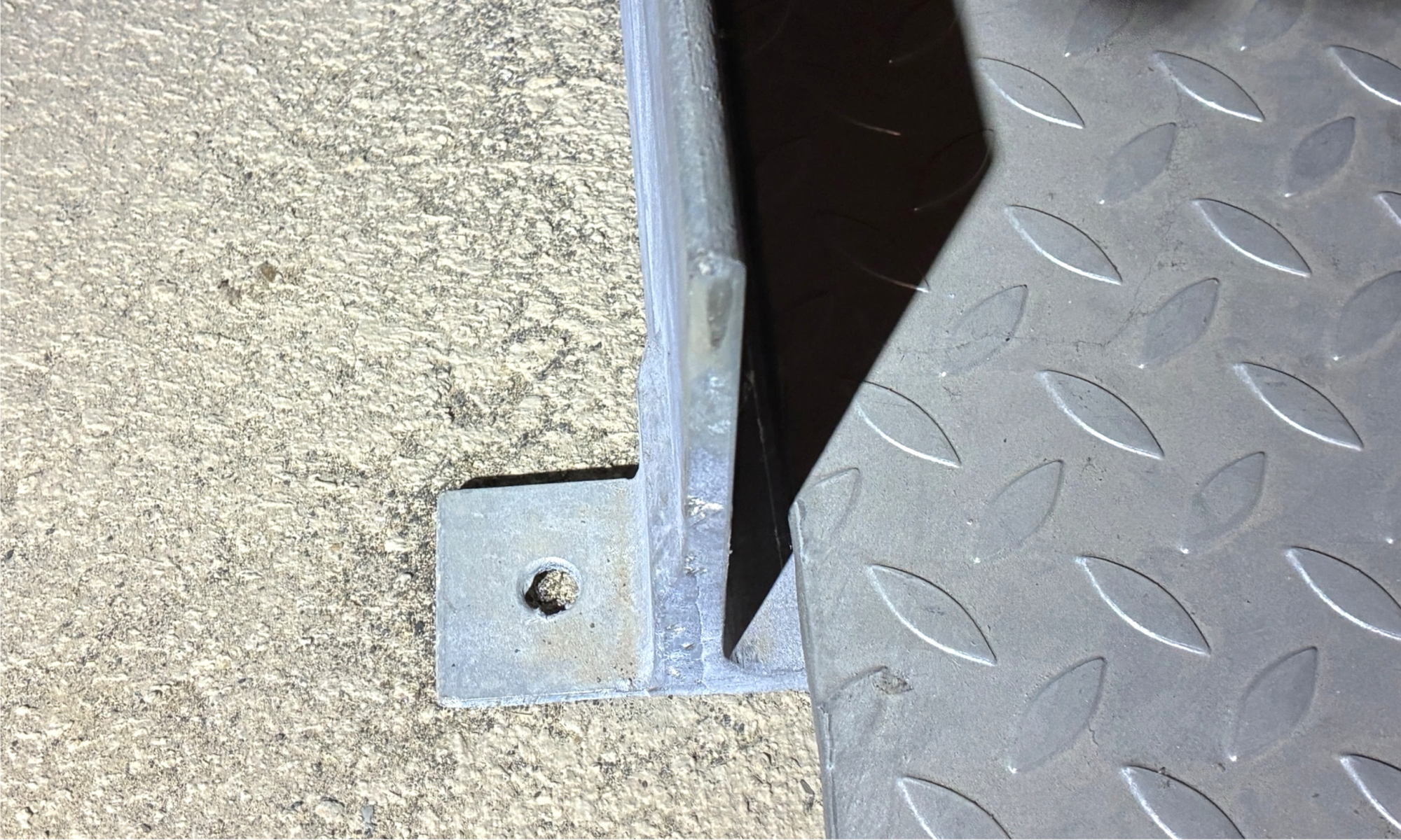 Fehlender Dübelanker an einer Stahlkonstruktion - nicht ausgeführter Verschraubung an der Bodenplatte